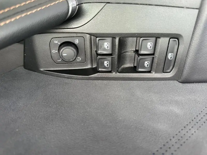 Vue rapprochée des commandes de lève-vitres et réglage des rétroviseurs côté conducteur du CUPRA Formentor blanc Nevada.