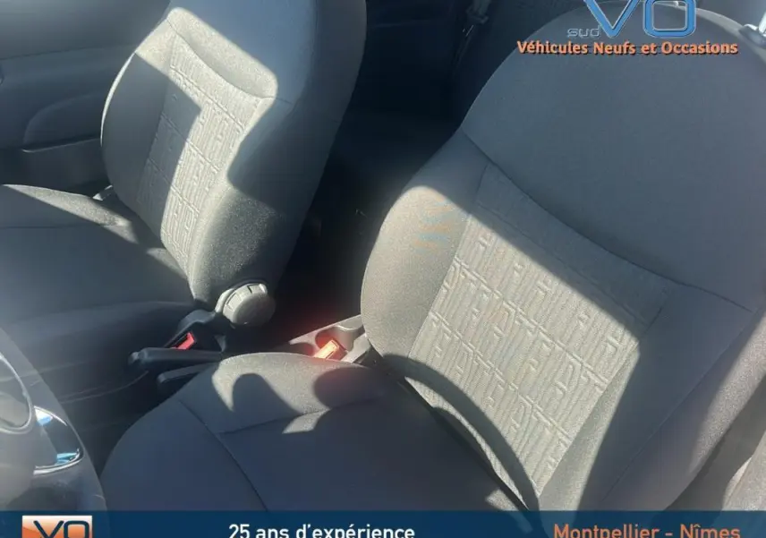 Gros plan sur les sièges avant gris du Fiat 500 2023, version hybride, montrant le tissu texturé et la console centrale.