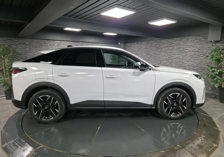 Peugeot 3008 blanc vue de profil côté gauche, avec jantes alliage noires et protections noires sur les bas de caisse.