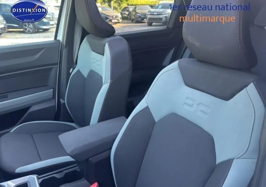 Gros plan sur les sièges avant bleu clair et noir avec accoudoir central du Dacia Bigster 2026 intérieur.