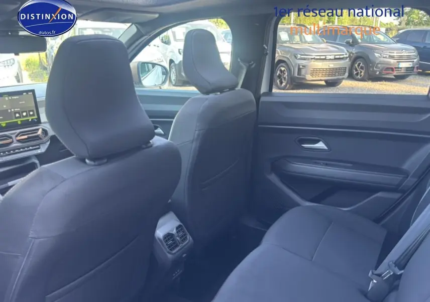 Vue intérieure arrière côté droit du Dacia Bigster 2026 avec sièges noirs et tablette tactile avant visible.