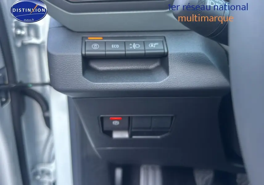 Détail des commandes sous le volant du Dacia Bigster blanc, avec boutons ECO et aide au démarrage en côte.