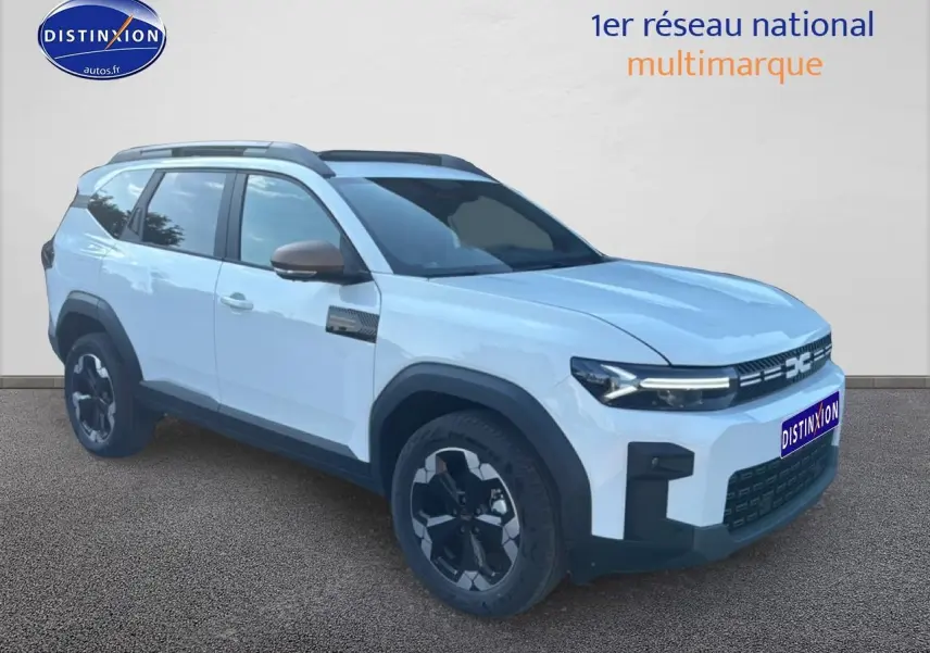 SUV Dacia Bigster blanc en 3/4 avant droit avec jantes noires et barres de toit visibles.