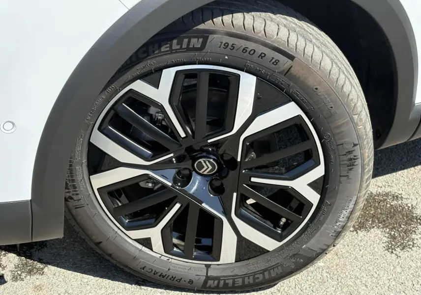 Gros plan sur la jante alliage 18'' diamantée noire et argentée du côté avant droit d'une Citroën C4 blanc Okénite.