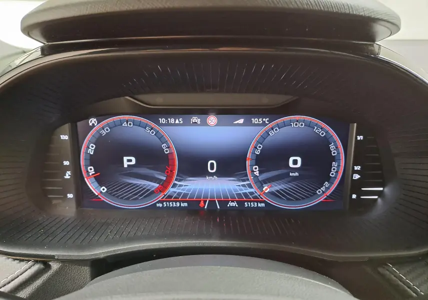 Tableau de bord numérique de la Skoda Fabia 2024 affichant la vitesse et le mode parking, vue frontale intérieure.