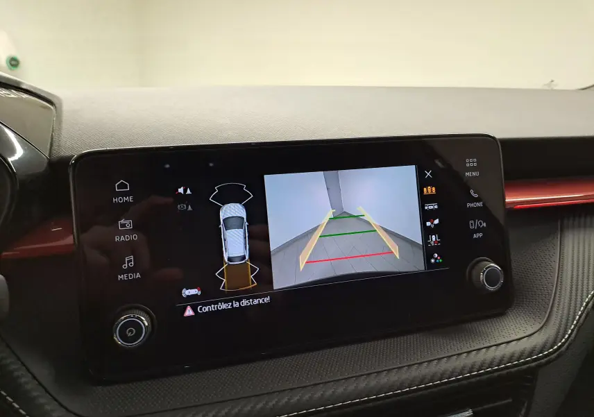 Écran central de la Skoda Fabia 1.5 TSI 150 DSG7 Monte-Carlo 2024 montrant la caméra de recul et l'aide au stationnement.