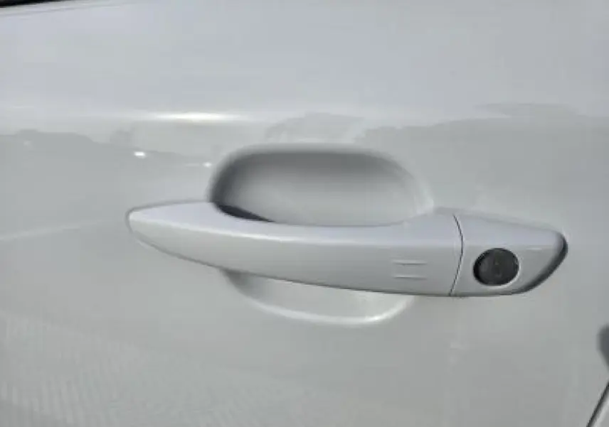 Gros plan sur l'emblème GT noir brillant sur la portière blanche du Peugeot 2008 II hybride 2025.