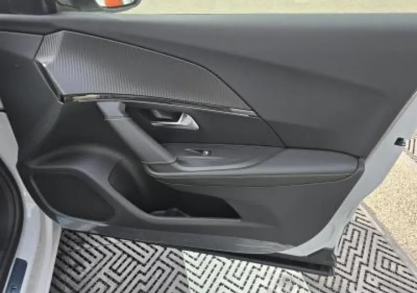 Poignée de porte blanche côté gauche du Peugeot 2008 hybride 2025 avec capteur d'ouverture intégré.