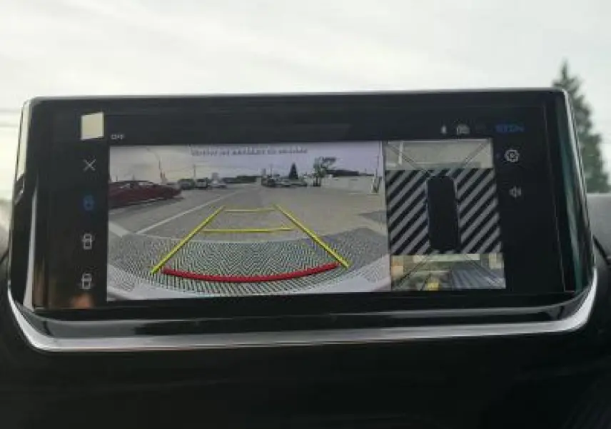 Vue intérieure du plafond avant du Peugeot 2008 blanc avec commandes d'éclairage et rétroviseur central visible