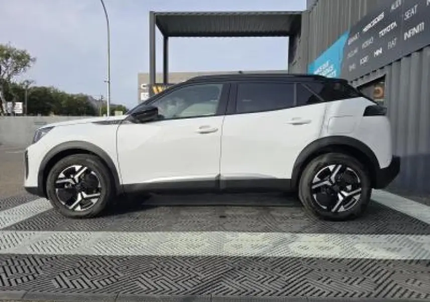 Vue 3/4 arrière droite du Peugeot 2008 blanc Okenite avec toit noir et jantes alliage bi-ton 17 pouces.