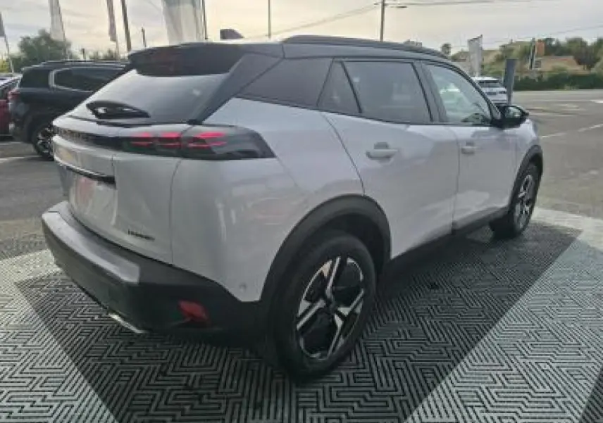 Vue arrière d'un Peugeot 2008 blanc Okenite avec toit noir, feux LED 3 griffes et double sortie d'échappement chromée.