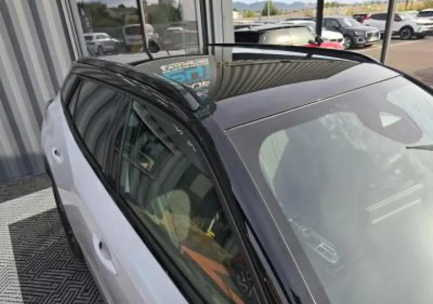 Vue 3/4 arrière droite du Peugeot 2008 blanc Okenite avec toit noir et jantes alliage bi-ton 17 pouces.