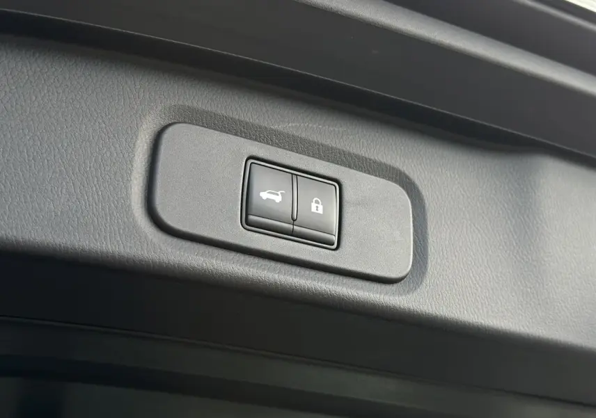 Boutons de hayon électrique et verrouillage intégrés dans le panneau intérieur du coffre du Nissan Qashqai noir nacré 2025.