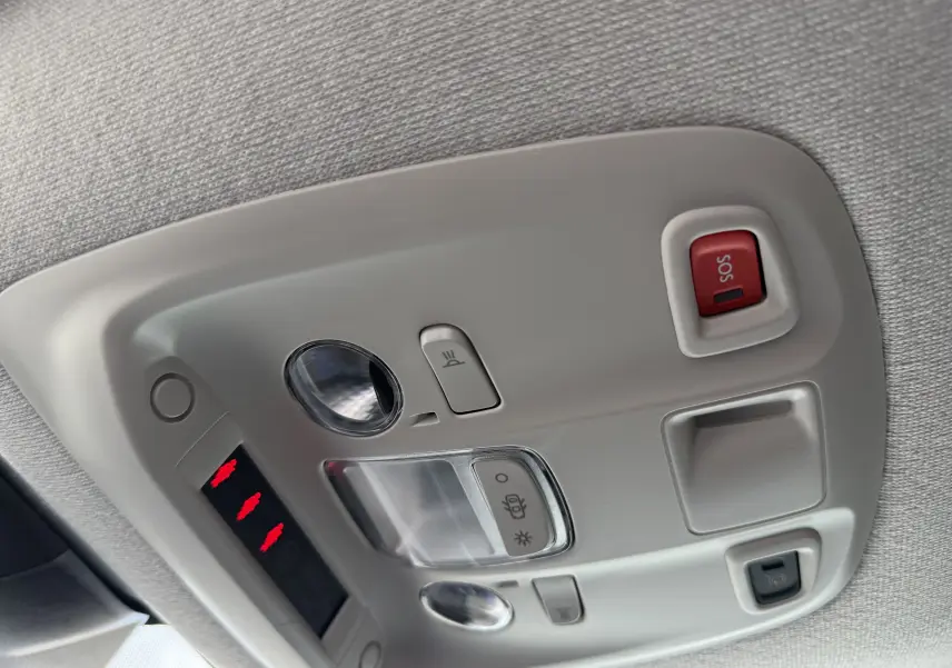 Vue en gros plan du plafonnier intérieur gris avec bouton SOS rouge et commandes d'éclairage du Citroën Jumpy noir.