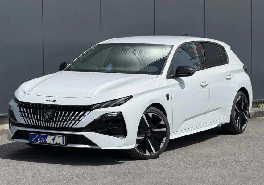 Peugeot 308 NV Hybrid blanc Okenite vue 3/4 avant droit avec jantes bi-tons et calandre distinctive noire.