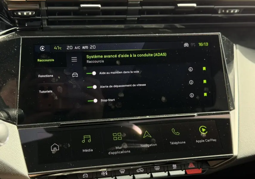 Écran tactile intérieur de la Peugeot 308 Hybrid affichant les aides à la conduite, avec tableau de bord clair.