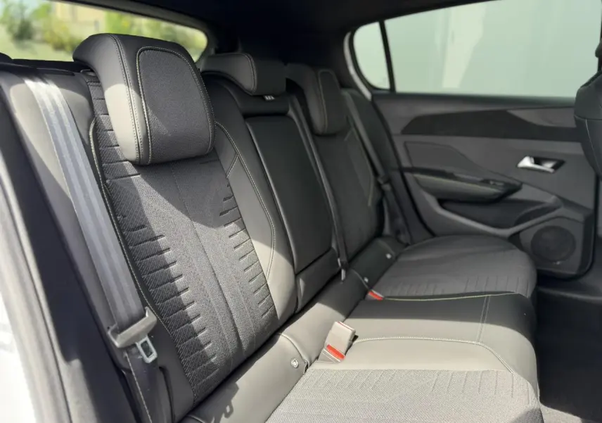 Vue intérieure des sièges arrière en tissu noir avec surpiqûres vert Adamite de la Peugeot 308 NV Hybrid 145 GT.