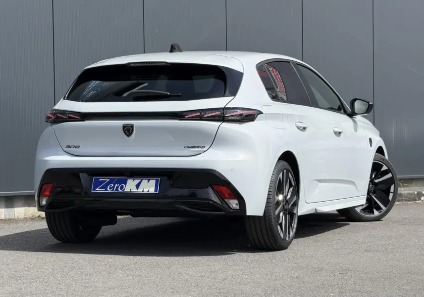 PEUGEOT 308 NV Hybrid blanc Okenite en 3/4 arrière droit, jantes alliage bi-tons et feux arrière LED 3 griffes.