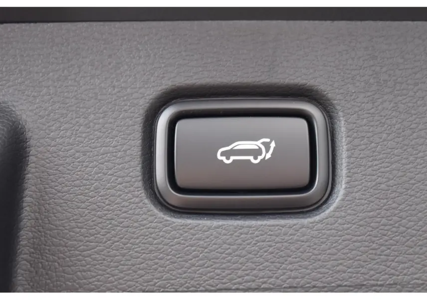 Bouton noir de commande d'ouverture électrique du hayon sur Kia Sportage Hybride 2026, vue en gros plan.
