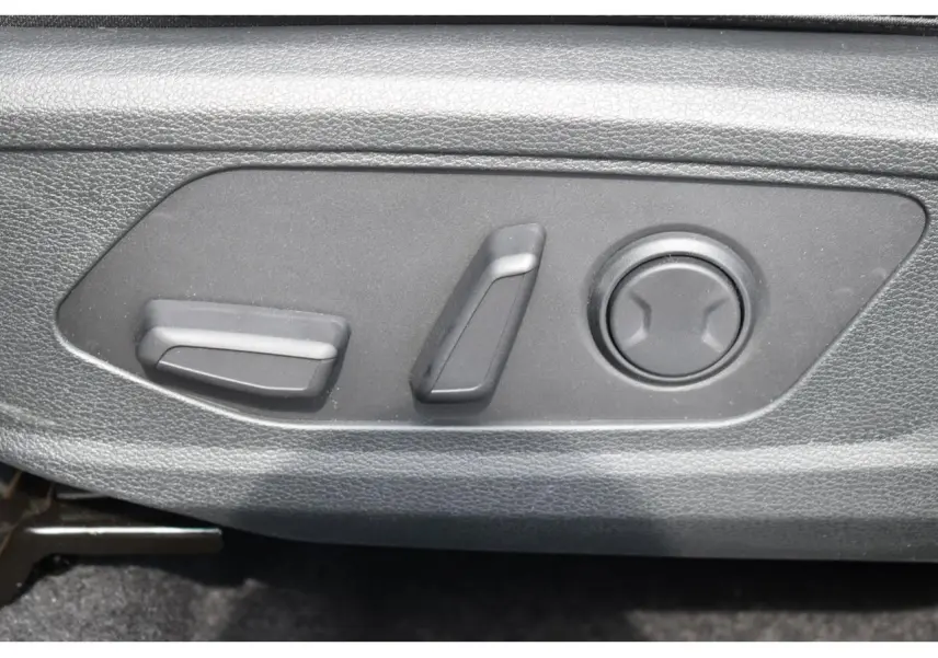 Gros plan sur les commandes électriques de réglage du siège avant du Kia Sportage noir hybride 2026.