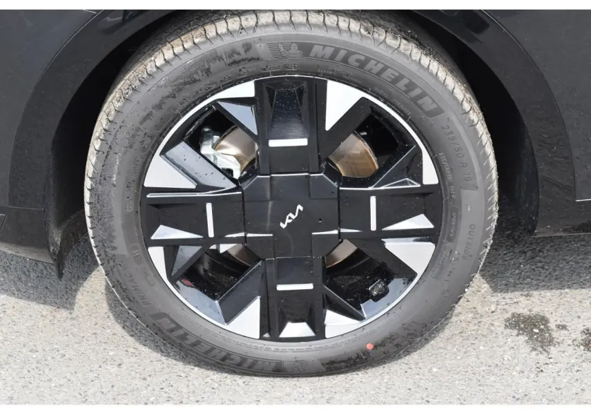 Gros plan sur la jante noire et argentée de 19 pouces du Kia Sportage hybride noir, avec pneu Michelin visible.