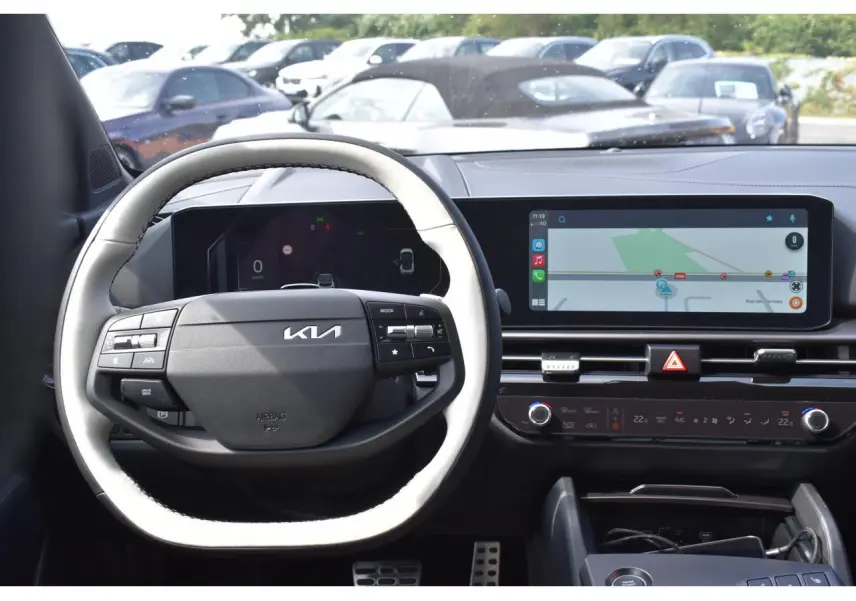 Vue intérieure centrée sur le volant noir et blanc du Kia Sportage 2026 avec écran tactile et tableau de bord digital.