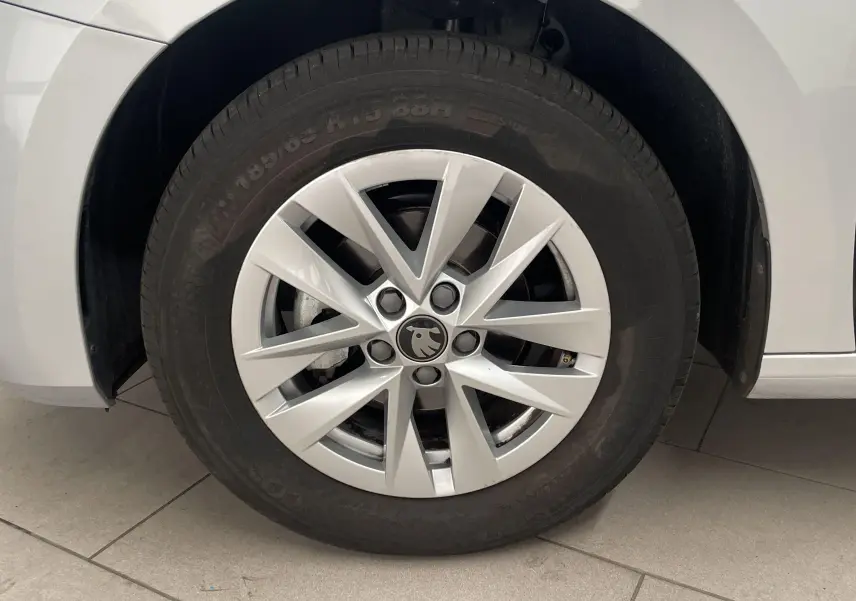 Gros plan sur la roue avant gauche d'une Skoda Fabia gris argent 2025 avec jante en alliage au design étoilé.