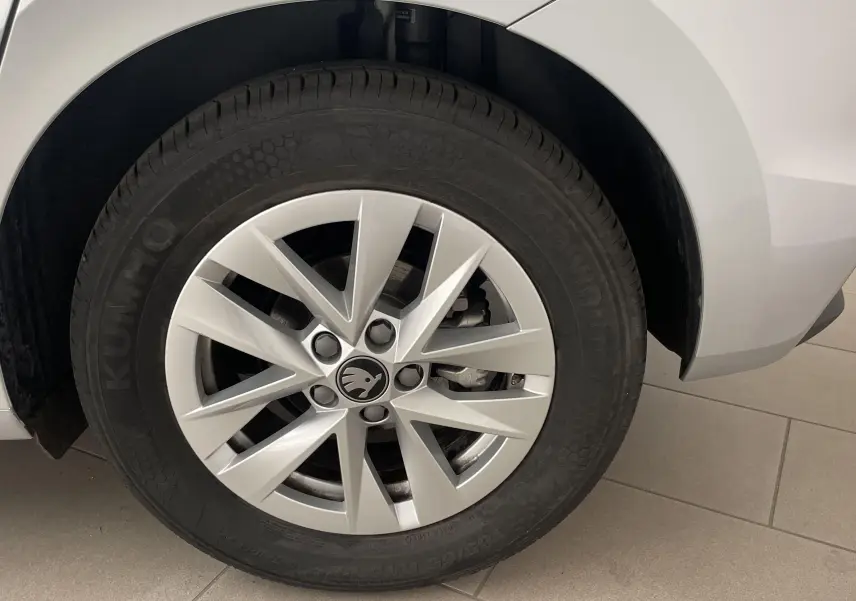 Gros plan sur la roue arrière droite gris argent d'une Skoda Fabia 2025 avec jante en alliage et logo central noir.