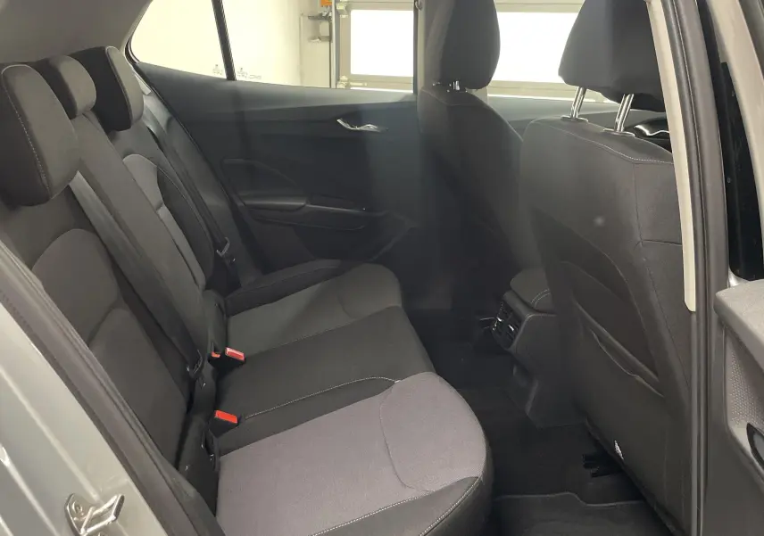 Vue intérieure côté gauche des sièges arrière noirs d'une Skoda Fabia gris argent 2025, avec appuie-têtes et porte ouvert.