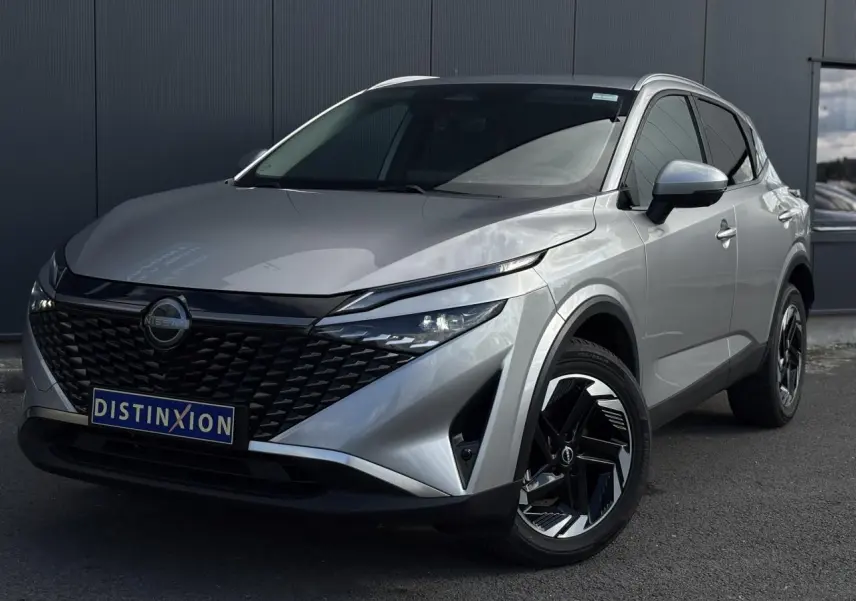 Nissan Qashqai 2024 gris métallisé en 3/4 avant droit avec calandre noire et jantes alliage noires.