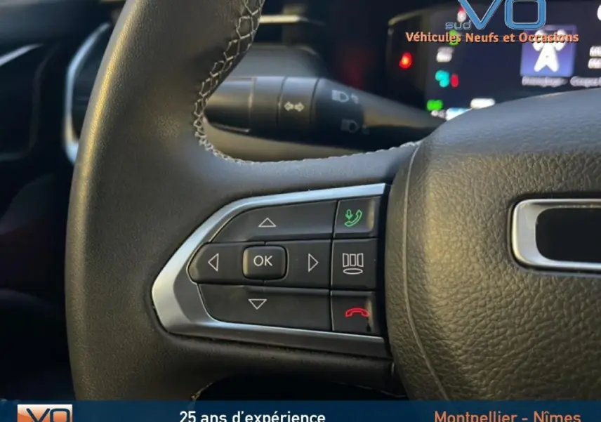 Gros plan sur les commandes du volant en cuir noir du Jeep Compass 2021, avec boutons de téléphone et navigation.