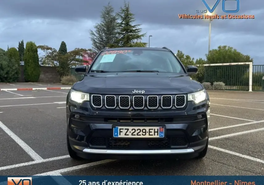 Vue frontale d'un Jeep Compass noir 2021 avec phares allumés et calandre distinctive à sept fentes.