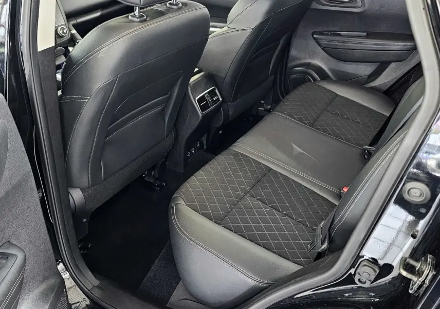 Vue intérieure arrière côté gauche du Renault Kadjar noir 2021, sièges en cuir noir avec surpiqûres et aérateurs centraux.