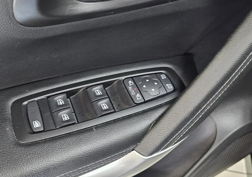 Détail des commandes de lève-vitres et réglage des rétroviseurs sur la portière côté gauche d'un Renault Kadjar noir.