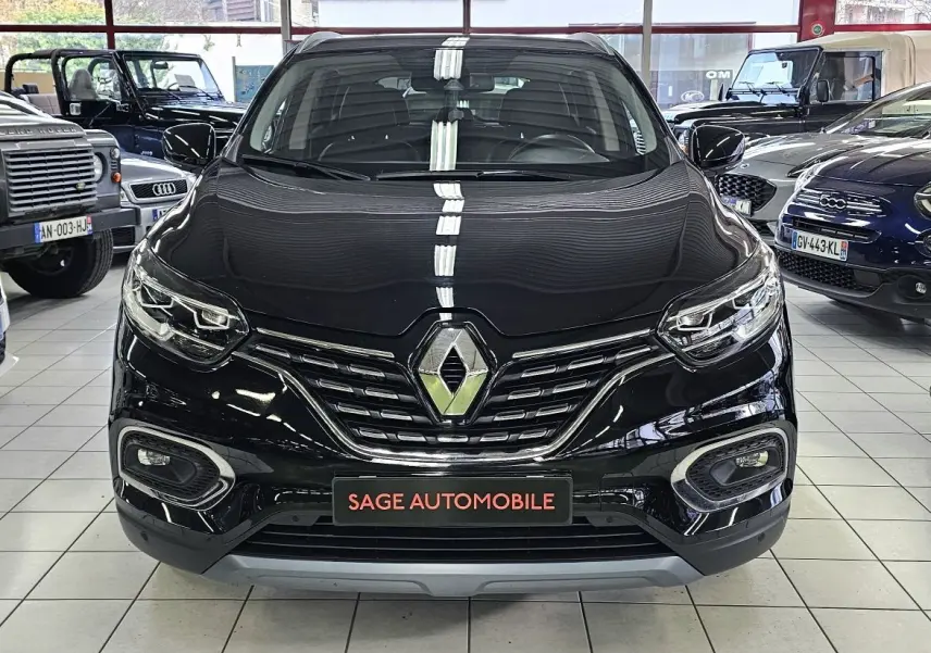 Vue frontale d'un Renault Kadjar noir 2021 en showroom, avec calandre chromée et phares LED distinctifs.