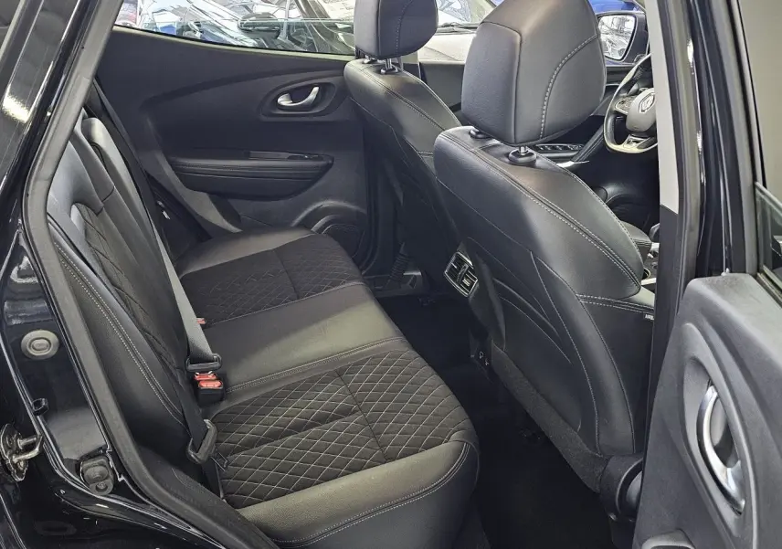 Vue intérieure côté gauche arrière du Renault Kadjar noir 2021, sièges en cuir noir avec surpiqûres et tableau de bord visible.