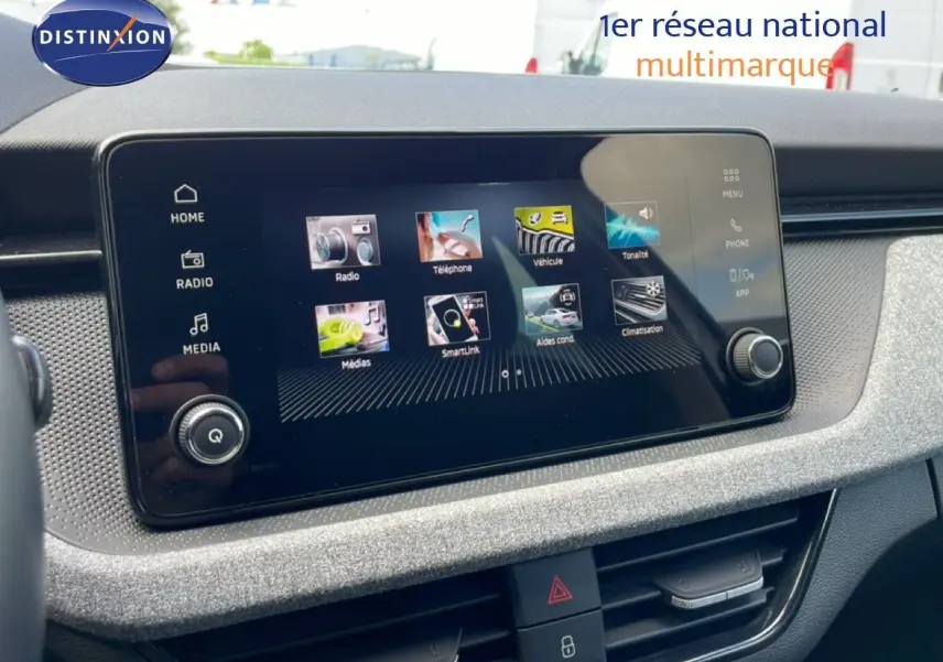 Écran tactile central du tableau de bord de la Skoda Scala blanc glacier, affichant les menus multimédias et connectivité.