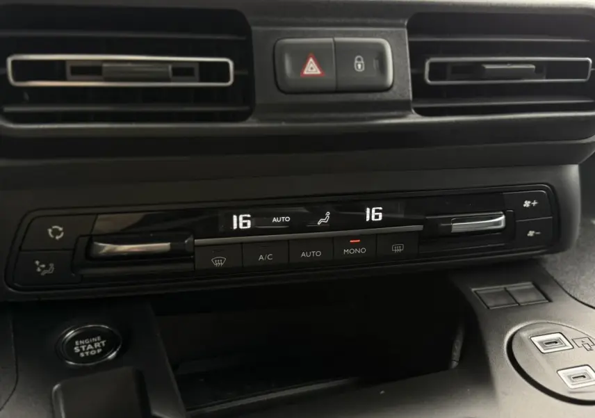 Gros plan sur la console centrale noire du Peugeot Rifter 2026, montrant la climatisation automatique bi-zone et le bouton start/stop.