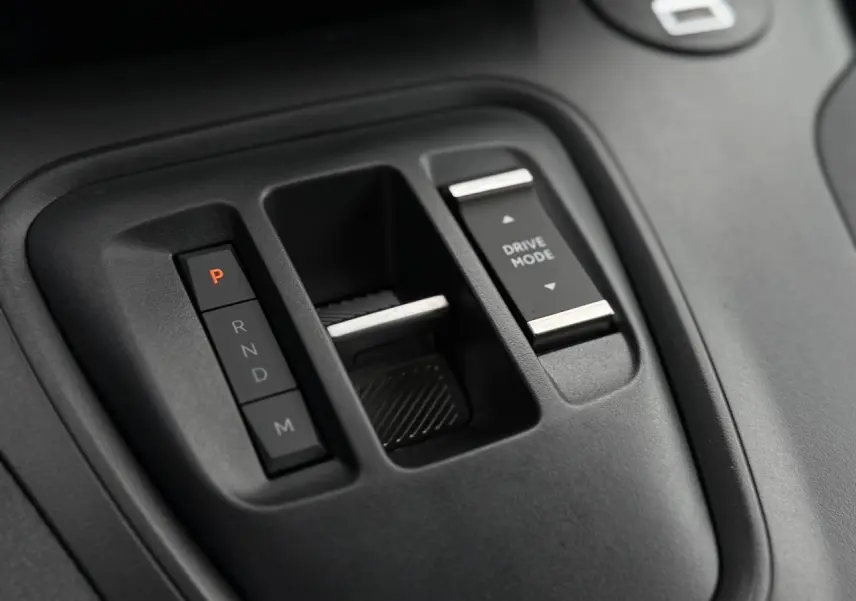 Gros plan sur la console centrale noire du Peugeot Rifter 2026 avec boutons de boîte auto et sélection Drive Mode.
