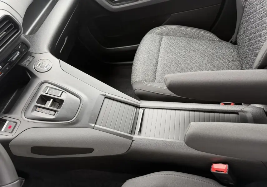 Vue intérieure centrée sur la console centrale et sièges avant gris du Peugeot Rifter M 1.5 BlueHDI 130 Allure 2026.