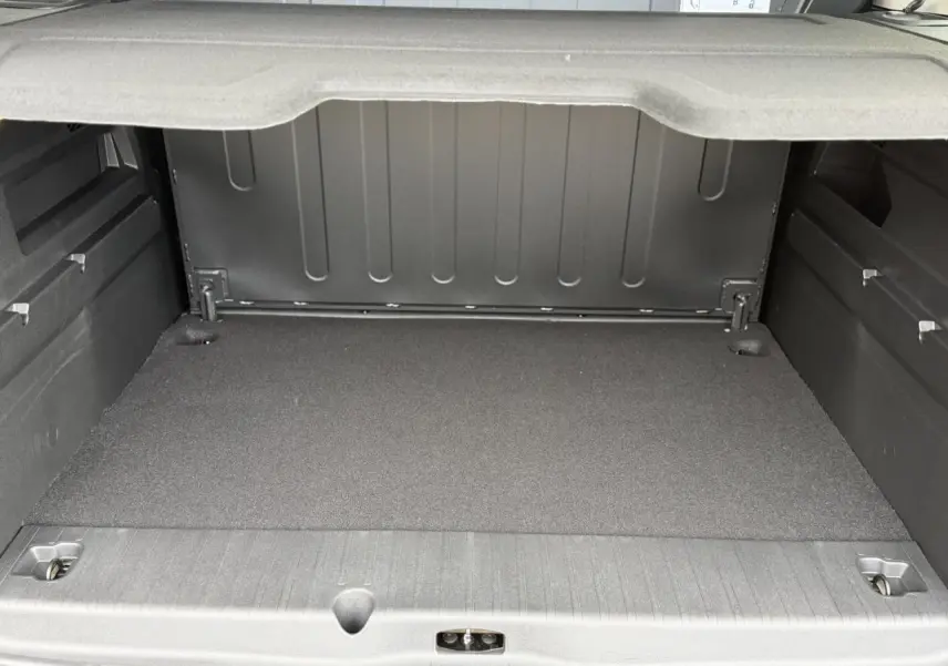 Coffre spacieux du Peugeot Rifter gris acier, vue intérieure arrière avec cache-bagages déployé.