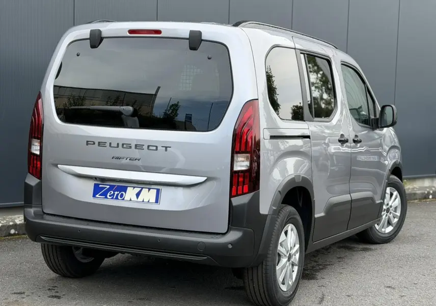Vue 3/4 arrière droite du Peugeot Rifter gris acier 2026 avec portes latérales coulissantes et feux arrière LED verticaux.