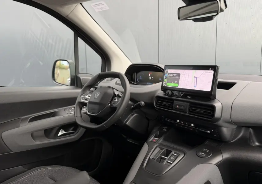 Vue intérieure côté conducteur du Peugeot Rifter gris acier 2026, avec tableau de bord numérique et écran tactile GPS.