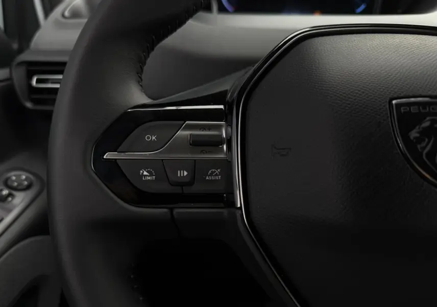 Gros plan sur le volant cuir multifonction du Peugeot Rifter 2026 avec commandes intégrées côté gauche.