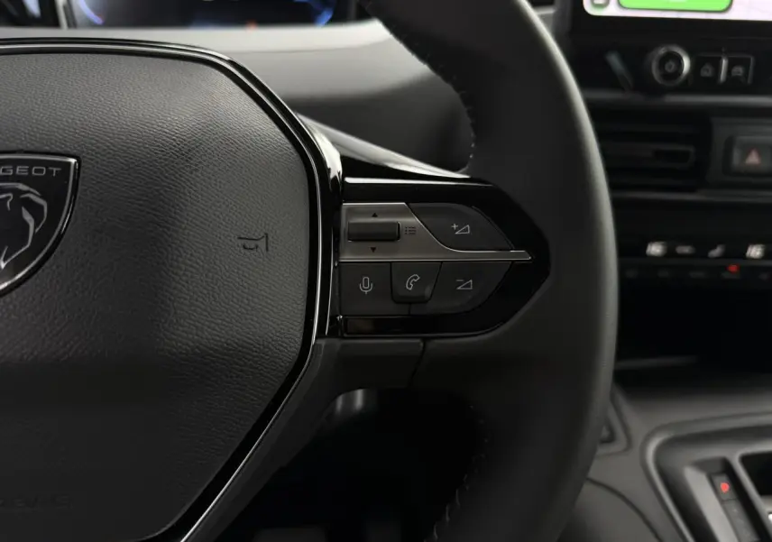Gros plan sur le volant cuir multifonction du Peugeot Rifter 2026 avec commandes vocales et téléphone intégrées.