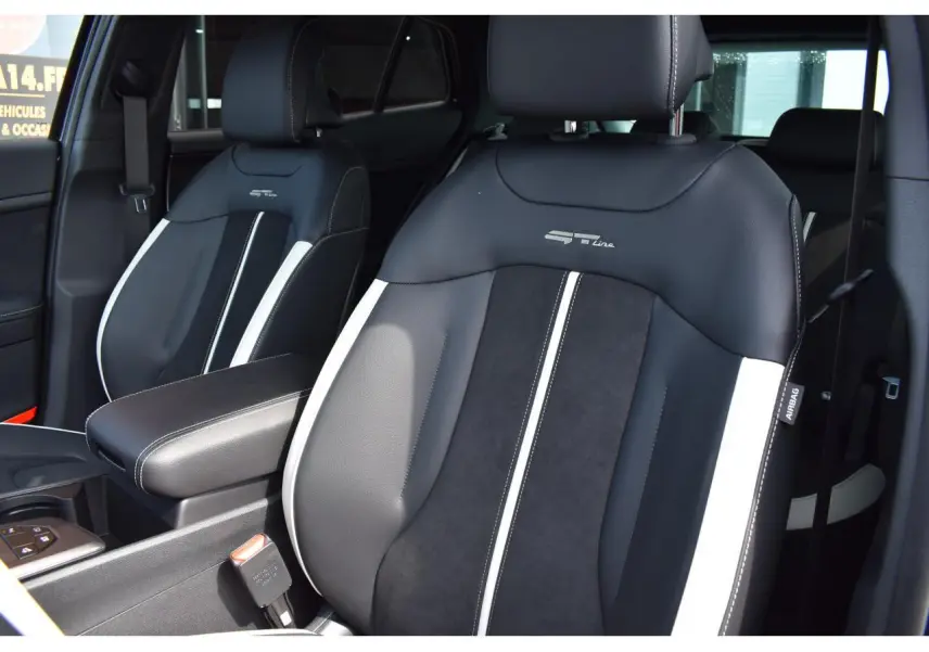 Gros plan sur les sièges avant bi-ton noir et gris du Kia Sportage GT-Line hybride 2026, avec logo GT-Line brodé.