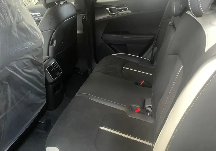 Vue intérieure côté droit des sièges arrière noirs avec surpiqûres blanches du Kia Sportage Hybride 2026 GT-Line.