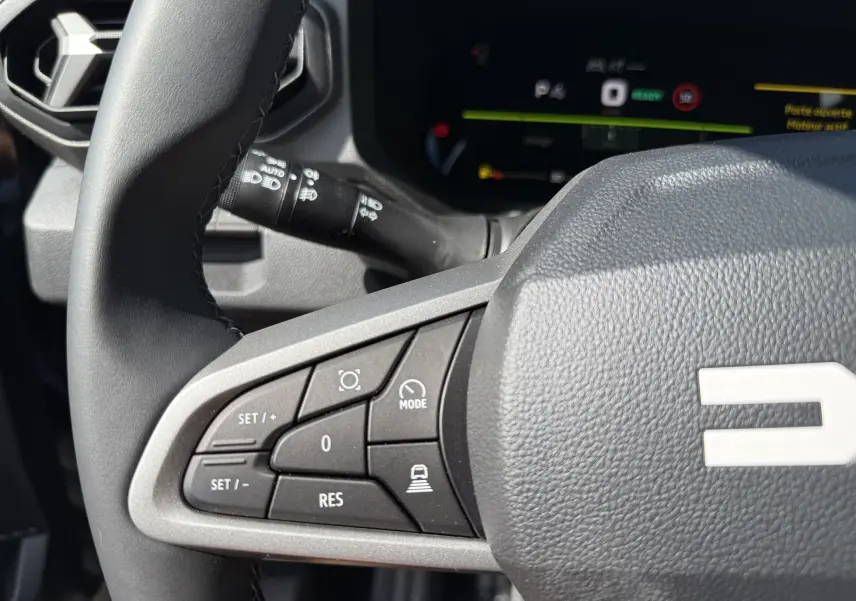 Gros plan sur la partie gauche du volant noir nacré du Dacia Bigster Hybrid 155 Journey avec commandes intégrées.