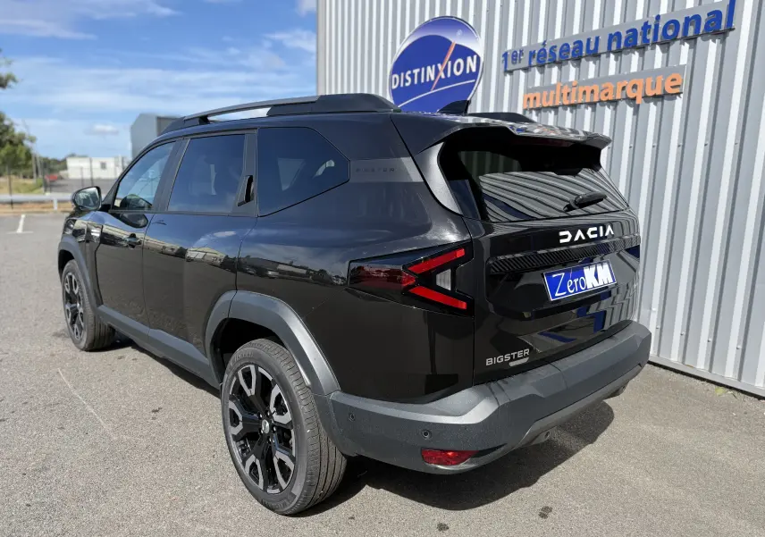 Vue 3/4 arrière droite du Dacia Bigster noir nacré avec feux arrière en forme de flèche et jantes noires biton.