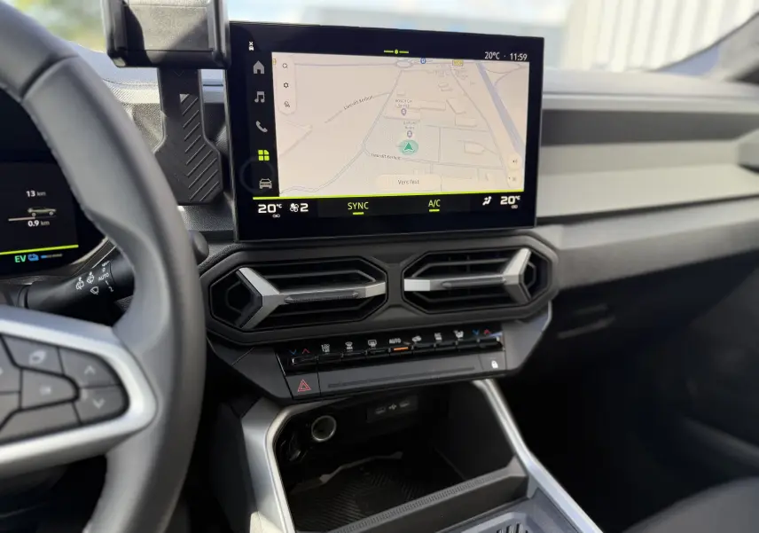 Vue intérieure du tableau de bord du Dacia Bigster Hybrid 155 Journey 2026, avec écran tactile central et commandes climatisation.